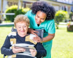 elderly looking at the tablet together with the caregiver